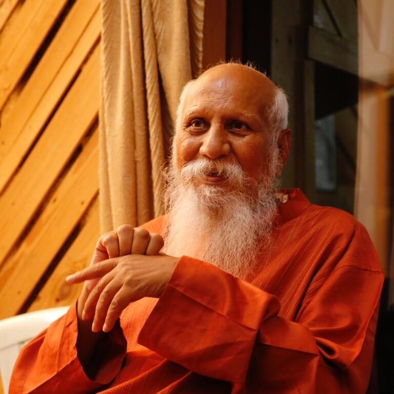 Brahmarshi Pitamaha Patriji smiling, in an orange robe